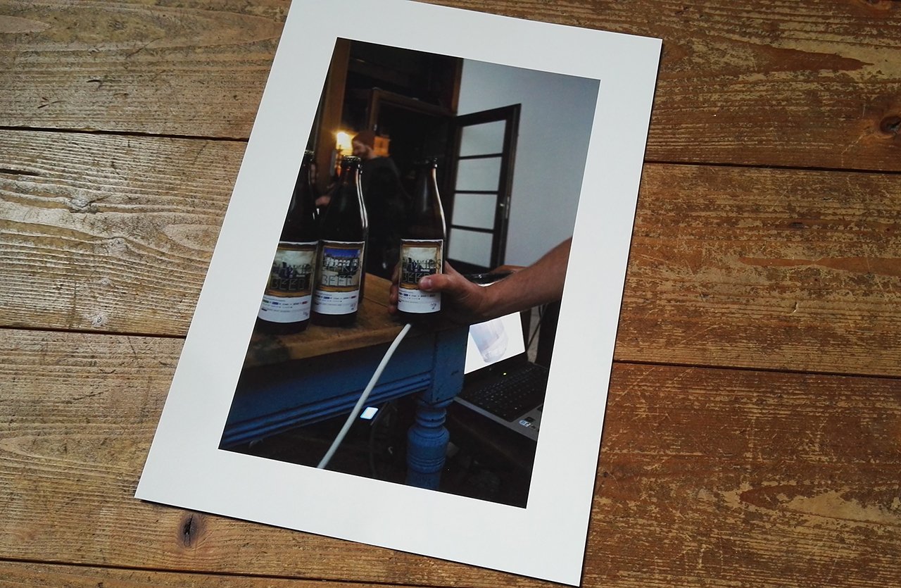 A work printed and mounted on paper, lying on a wooden floor