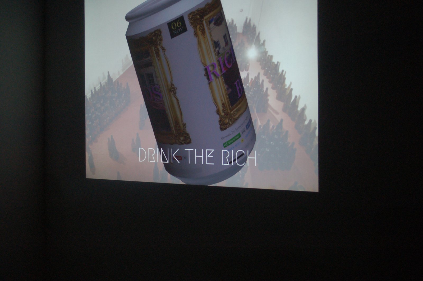 The animated beer label projected large on a wall in a darkened room